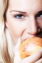 Close-up portrait of a woman bitting an apple