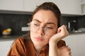Close up portrait of woman in glasses with concerned, sad face, looking upset, troubled expression, sitting at home