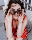 Close-up portrait of a woman with glasses. Photo of a fashionable girl with beautiful brown hair smiling at the camera. Royalty Free Stock Photo