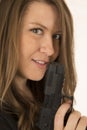 Close-up portrait of a woman holding a pistol with a smirk on he