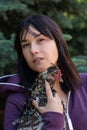 Close up portrait of woman with a motley chicken in her h