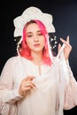 Close-up portrait of a woman with pink hair in a white dress with a kokoshnik on her head posing isolated on a black background Royalty Free Stock Photo