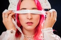 Close-up portrait of a woman with pink hair in a white dress with a kokoshnik on her head posing isolated on a black background Royalty Free Stock Photo