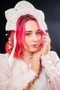 Close-up portrait of a woman with pink hair in a white dress with a kokoshnik on her head posing isolated on a black background Royalty Free Stock Photo