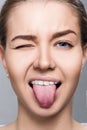 Close-up portrait of woman shows tongue grimace. Royalty Free Stock Photo