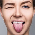 Close-up portrait of woman shows tongue grimace. Royalty Free Stock Photo