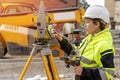 portrait of a woman site engineer surveyor working with theodolite total station EDM equipment on a building construction Royalty Free Stock Photo