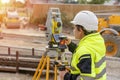 a woman site engineer surveyor working with theodolite total station EDM equipment on a building construction Royalty Free Stock Photo