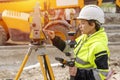 portrait of a woman site engineer surveyor working with theodolite total station EDM equipment on a building construction Royalty Free Stock Photo