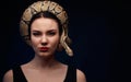 Close up portrait of woman with snake around her head on dark ba