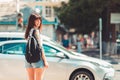 Close up portrait of a woman stands near a road. In the background, a car is driving along the road and traffic light is red. Royalty Free Stock Photo