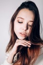 Close up portrait of woman on white background. Brunette girl looking down.