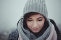 Close up portrait of woman who looking down on misty background. Photo of beautiful fashion model with a cap in winter time. Girl Royalty Free Stock Photo