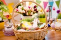 Close up portrait of wooden basket with easter composition, sweets, choco, gingerbread standing on table over decorative