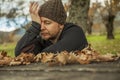 Close up portrait worried man with wool hat sitting on a bench. Royalty Free Stock Photo