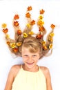 Adorable smiling child with healthy and strong long blond hair in shape of fire with floral arrangement