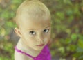 Close up portrait of 3 years old girl in pink summer dress with very short hair and big beautiful eyes. Not all baby girls have Royalty Free Stock Photo
