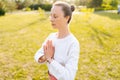 Close-up portrait of yogini female with emotion of serenity and tranquility performing Namaste gesture on nature, closed Royalty Free Stock Photo