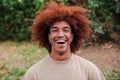 Close up portrait of young african american toothy man with afro hair smiling looking at camera outdoors. Head shot of a Royalty Free Stock Photo