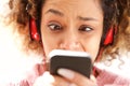 Young african american woman with confused expression when looking at cellphone Royalty Free Stock Photo