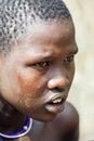 Close up Portrait of Young African Woman with the cut hair in the local Mursi tribe village