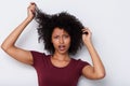 Close up young african woman pulling bad curly hair and looking worried