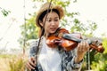 Close-up portrait of Young Asia woman music violinist play violin, relax in the garden with peace of mind Royalty Free Stock Photo