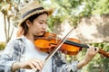 Close-up portrait of Young Asia woman music violinist play violin, relax in the garden with peace of mind Royalty Free Stock Photo