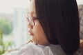 Close up portrait of young asian girl wearing glasses looking away. Natural lights