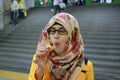 Close up portrait of young Asian muslim woman wearing colorful hijab and eyeglasses inside Kyoto railway station Royalty Free Stock Photo