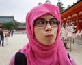 Close up portrait of young Asian muslim woman wearing hijab and eyeglasses in Japan with duck face expression Royalty Free Stock Photo