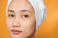 Close-up portrait of young Asian woman with perfect health skin of face. Isolated on orange background Royalty Free Stock Photo