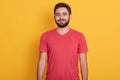 Close up portrait of young attractive bearded guy with beautiful eyes, wearing red t shirt, looking at camera with happy and Royalty Free Stock Photo