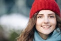 CLose up Portrait young attractive curly haired smile woman with red hat look at camera at city center feel happy Royalty Free Stock Photo