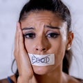 Close up portrait of young attractive latin woman with mouth sealed on stick tape with text no food in diet Anorexia eating