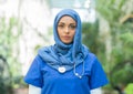 Close-up portrait of young and attractive muslim woman nurse in hijab. Middle Eastern female doctor outdoor on the Royalty Free Stock Photo