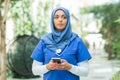 Close-up portrait of young and attractive muslim woman nurse in hijab. Middle Eastern female doctor outdoor on the Royalty Free Stock Photo