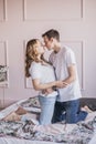 Close up portrait of young attractive romantic couple hugging and kissing, laying down on a bed, being loving with each other Royalty Free Stock Photo