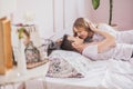 Close up portrait of young attractive romantic couple hugging and kissing, laying down on a bed, being loving with each other. Royalty Free Stock Photo