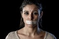 Close up portrait of young attractive woman with mouth and lips sealed in adhesive tape restrained Royalty Free Stock Photo