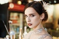 Close-up portrait of a young attractive woman in a 1920s style at the bar. Model with a beautiful make-up Royalty Free Stock Photo