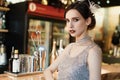 Close-up portrait of a young attractive woman in a 1920s style at the bar. Model with a beautiful make-up Royalty Free Stock Photo