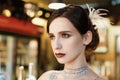 Close-up portrait of a young attractive woman in a 1920s style at the bar. Model with a beautiful make-up Royalty Free Stock Photo