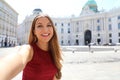 Close up portrait of a young attractive woman taking a selfie self portrait with smartphone or digital camera in Vienna, Austria.