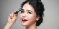 Close up portrait of young beautiful Asian woman applying mascara on her eye Royalty Free Stock Photo