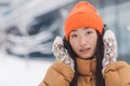 Close-up portrait of a young beautiful Asian woman looking at the camera and smiling while listening to music with big headphones Royalty Free Stock Photo