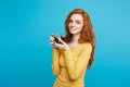 Close up Portrait young beautiful attractive ginger girl happy smiling with vintage camera and ready to travel. Blue