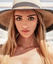 Close-up portrait of a young beautiful blonde caucasian girl with a perfect face and big eyes wearing a hat on a hot summer day. Royalty Free Stock Photo