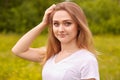 Close up portrait of young beautiful blonde woman with staright hair, posing in meadow in sunny summer or spring day, looking Royalty Free Stock Photo