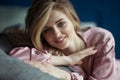 Close-up portrait of young beautiful blonde woman with wavy hair in a pink peignoir with a plunging neckline Royalty Free Stock Photo